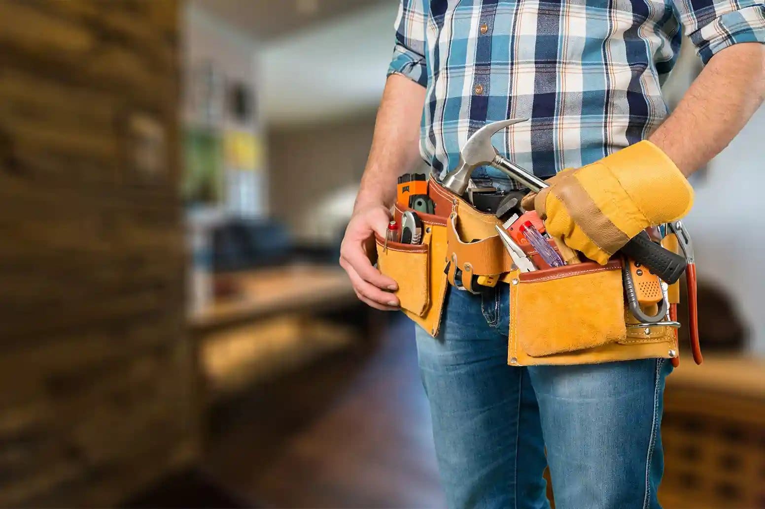 Wellington handyman wearing a loaded leather tool belt inside a home