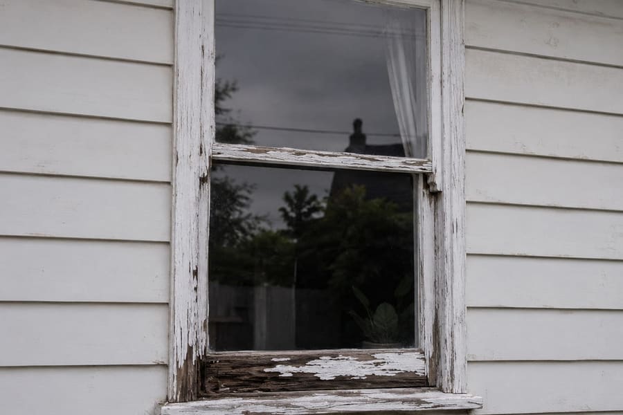 Timber window with rotted sill and peeling paint before repair